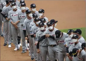  ??  ?? Hanwha Eagles players wearing face masks line up before the start of their Korea Baseball Organizati­on regular-season opener against SK Wyverns on Tuesday in Incheon, South Korea.