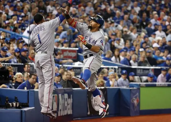  ?? STEVE RUSSELL/TORONTO STAR ?? Texas Rangers second baseman Rougned Odor celebrates his seventh-inning home run with teammate Elvis Andrus. Odor, who was twice hit by pitches, scored three of the Rangers’ five runs.