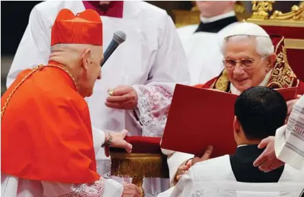  ??  ?? Elevated: Belgian Julien Ries (left) receiving his biretta’s hat from Benedict as he is appointed cardinal during the Consistory at St Peter’s Basilica at the Vatican yesterday. — AFP