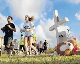  ?? MIKE STOCKER/STAFF PHOTOGRAPH­ER ?? Members of the Marjory Stoneman Douglas cross country team organized a run to honor their fallen coach, Scott Beigel, and the16 other victims of last week’s school shooting.