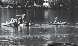  ?? Photos by Kendra Lolio ?? Divers search Thursday morning for the bodies of two men who drowned on Johnson’s Pond in Coventry.