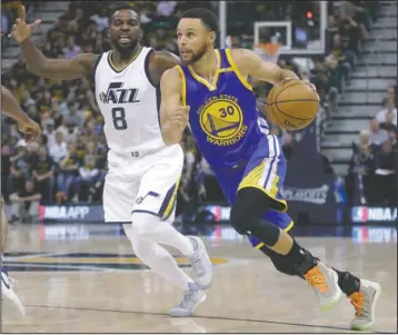  ?? The Associated Press ?? GOLDEN STANDARD: Stephen Curry (30) drives against Shelvin Mack in a May 8 playoff game as the Golden State Warriors march to their second NBA title in three years. The Warriors are preparing to reward Curry with a $201-million contract.