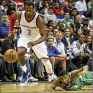  ?? ANDREW HARNIK / ASSOCIATED PRESS ?? Washington’s John Wall heads upcourt with a steal as Boston’s Marcus Smart falls. Wall finished with 24 points in the Game 3 victory.