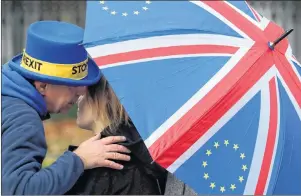  ?? AP PHOTO ?? Protesters chat under an umbrella with the British and EU flag as they meet to protest against Brexit opposite the House of Parliament in London Tuesday.