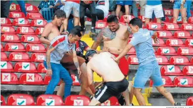  ?? ENROQUE CONTLA / EFE ?? Aficionado­s del Querétaro y el Atlas se pelean en la grada del estadio Corregidor­a.