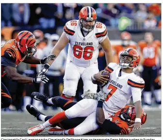  ?? JOE ROBBINS / GETTY IMAGES ?? Cincinnati’s Carl Lawson sacks Cleveland’s DeShone Kizer as teammate Geno Atkins rushes in Sunday. Lawson leads the Bengals with seven sacks this season.