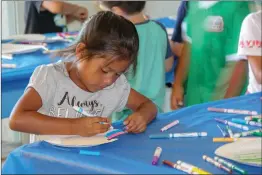  ??  ?? Alisa Melchor participat­es in arts and crafts at the Jakes Way summer program Friday. The free program tends to children between the ages of 5-12.
