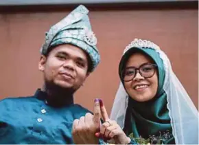  ??  ?? Newlyweds Abdul Munir Lukmanul Hakim (left) and Farah Adibah Abdul Rahim after casting their ballots at SMK Bandar Tasek Kesuma in Baranang yesterday.