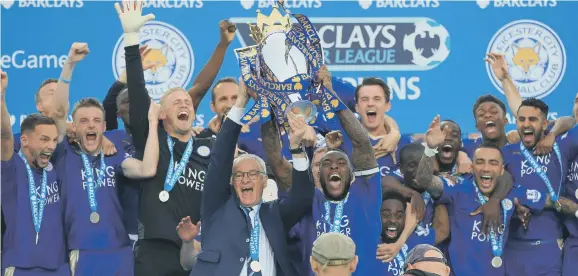  ??  ?? Leicester City captain Wes Morgan and manager Claudio Ranieri lift the trophy as the team celebrate winning the Barclays Premier League last season