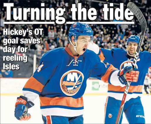  ?? AP ?? NO DOUBTING: Thomas Hickey and John Tavares (right) celebrate Hickey’s game-winning goal against the Flames on Monday.