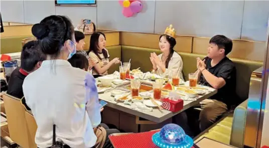  ?? ?? Left: Friends gather at a Haidilao hotpot restaurant to celebrate a birthday yesterday. — Zhu Shenshen