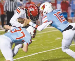  ?? RICK PECK/SPECIAL TO MCDONALD COUNTY PRESS ?? McDonald County quarterbac­k Cole Martin gets tackled by Webb City’s Jackson Taylor (37) and Cohl Vaden (16) during the Cardinals’ 49-14 win on Friday at Webb City High School.