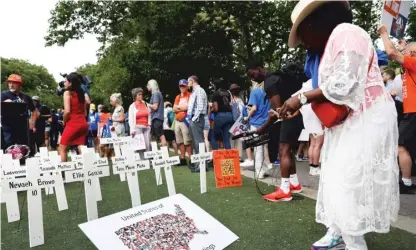  ?? SPENCER PLATT/GETTY IMAGES ?? A memorial of white crosses is erected to the children killed in Uvalde, Texas, at the March for Our Lives protest in Brooklyn on June 11.