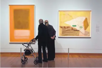  ??  ?? Clarence Giese and Ingrid Vollnhofer check out Mark Rothko’s “Old Gold Over White,” left, and Kenzo Okada’s “Abstractio­n No. 7” during a recent visit to the Albuquerqu­e Museum.