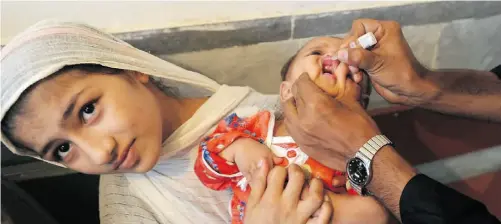  ?? A. MAJEED/AFP/GETTY Image
s ?? A Pakistani health worker gives the polio vaccine to a child in Peshawar. The country has recorded 35 cases of the disease this year.