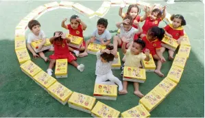  ??  ?? Children at British Orchard Nursery with Lakum boxes packed by them. The boxes include toys, education materials and hygiene items that would be distribute­d to kids around the world.