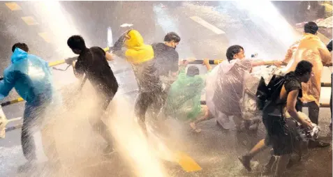  ?? Soe Zeya Tun/ Reuters ?? Police sprays protesters with a water cannon