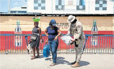  ?? [Reuters] ?? Kleiner Grenzverke­hr: Haitianer überqueren die Grenze in die Dominikani­sche Republik, um auf Märkten einzukaufe­n.