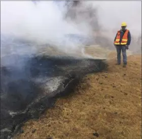  ?? U.S. GEOLOGICAL SURVEY VIA AP ?? A geologist examines a part of the inactive fissure 10 in Leilani Estates subdivisio­n near Pahoa on the island of Hawaii.