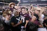  ?? SAM CRAFT — THE ASSOCIATED PRESS ?? Texas A&M quarterbac­k Zach Calzada (10) is surrounded by fans after the team’s win over Alabama in an NCAA college football game Saturday, Oct. 9, 2021, in College Station, Texas.