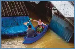  ??  ?? GAMBAR menunjukka­n satu keluarga di daerah Sungai Golok, Narathiwat menaiki sampan untuk berpindah ke tempat selamat. - AFP