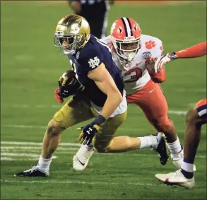  ?? Brian Blanco / Associated Press ?? Notre Dame wide receiver Ben Skowronek (11) evades Clemson defensive tackle Tyler Davis during a carry in the second half of the ACC championsh­ip earlier this month.