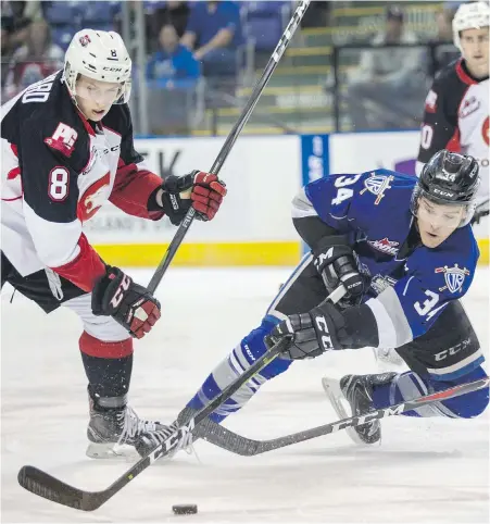  ??  ?? Victoria Royals’ Kaid Oliver grabs the puck in front of Prince George Cougars’ Jackson Leppard in WHL action at Save-on-Foods Memorial Centre on Saturday.