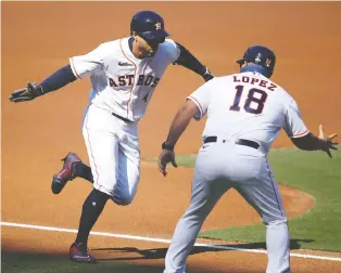  ?? SEAN M. HAFFEY/ GETTY IMAGES ?? George Springer of the Houston Astros celebrates with third base coach Omar Lopez after hitting a homer against the Tampa Bay Rays to open the scoring on Thursday in Game 5 of the ALCS.