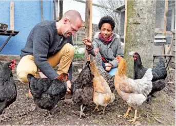  ??  ?? Dirk Gratzel (left) and neighbor kid Elias feed their chicken in Stollberg, western Germany. Gratzel counts his carbon emissions. — IC