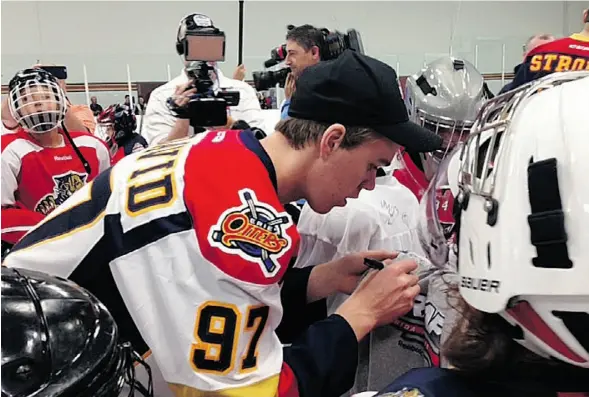  ?? Joanne Ireland/Edmonton Journal ?? Connor McDavid signs autographs while taking part in a hockey clinic with other top NHL draft prospects at the Florida Panthers’ Ice Den on Thursday.