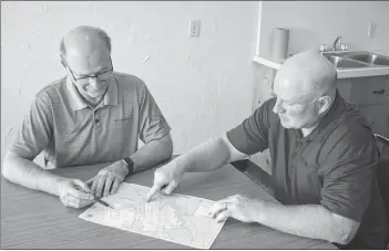  ??  ?? Coun. Terry Bernard, chairman of Charlottet­own’s public works committee, and Mike Connolly, executive director of Cycling P.E.I., look over the new map created by the city and Cycling P.E.I. that shows every cycling route in the capital, as well as all...