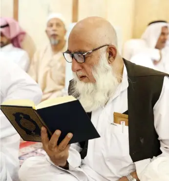  ??  ?? مسن يقرأ القرآن الكريم بعد صالة التراويح في املسجد النبوي الشريف. (واس)