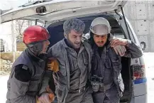  ?? Syrian Civil Defense White Helmets / Associated Press ?? Civil Defense workers help a co-worker on Saturday after airstrikes hit a main street, killing scores of people in the Damascus suburb of Hamouriyeh, Syria.