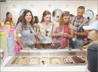  ??  ?? Customers look over the offerings at the Dō Cookie Dough Confection­s shop.