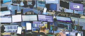  ?? LUCAS JACKSON / REUTERS ?? Traders work on the floor of the New York Stock Exchange on Friday.