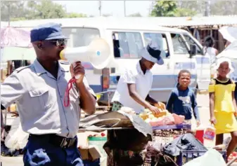  ??  ?? Sgt Zenzo Mpofu yesterday addresses Nkulumane residents during a crime awareness campaign in the district