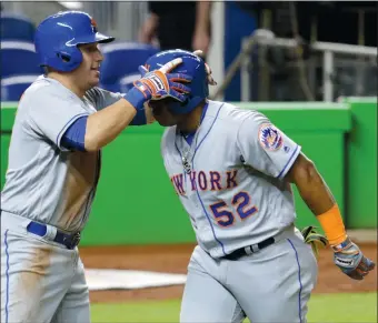  ?? LYNNE SLADKY/AP PHOTO ?? New York Mets’ Asdrubal Cabrera, left, greets Yoenis Cespedes at the plate after Cespedes hit a two-run home in the third inning of Tuesday’s 12-1 win over the Marlins in Miami.