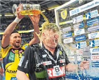  ??  ?? Alexander Petersson von den Rhein-Neckar Löwen (li.) und Trainer Nikolaj Jacobsen feiern mit einer Bierdusche die – mit Erfolg verteidigt­e – Deutsche Meistersch­aft.