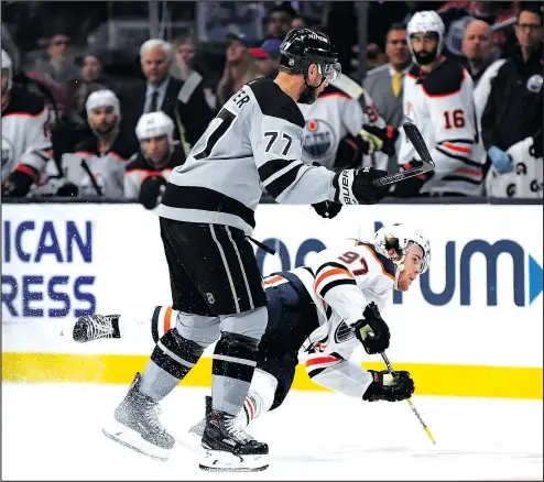  ?? — GETTY IMAGES ?? It was a rough Saturday for Edmonton Oilers superstar Connor McDavid, seen here getting checked hard by Los Angeles KIngs forward Jeff Carter at the Staples Center. McDavid also got an elbow to the jaw from Kings defenceman Drew Doughty that went uncalled by the referees.