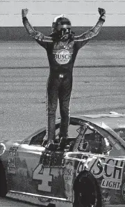  ?? [ED ZURGA/THE ASSOCIATED PRESS] ?? Kevin Harvick stands on his car as he celebrates his win in Saturday’s NASCAR Cup Series race at Kansas Speedway in Kansas City, Kan.