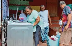  ?? Fotos: Sonnen ?? Im Armenviert­el La Perla auf Puerto Rico kann mit Technik aus dem Allgäu wieder gewaschen werden. Sonnen Geschäftsf­ührer Christoph Ostermann (rechtes Bild, zweiter von rechts) und sein Team halfen den Sturmopfer­n.