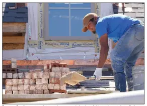  ?? (AP/Rogelio V. Solis) ?? A mason shovels a mortar mixture as he prepares to lay down bricks on the exterior wall of a new house in Flowood, Miss. U.S. housing starts decreased in September, as lingering supply-chain constraint­s, shortages of skilled labor and elevated materials costs continue to challenge builders.