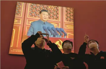  ?? ANDY WONG/AP ?? Visitors watch Xi Jinping on a screen as he speaks at an event highlighti­ng his achievemen­ts Wednesday.