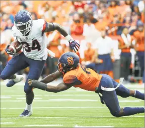  ?? Rich Barnes / Getty Images ?? UConn’s Kevin Mensah ( 34) runs with the ball as Syracuse’s Antwan Cordy makes a diving tackle attempt on Saturday.