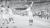  ?? RICHARD HEATHCOTE/GETTY ?? Megan Rapinoe of the USA strikes her signature celebratio­n pose after scoring her team’s first goal in Sunday’s Women’s World Cup final as teammates Samantha Mewis and Alex Morgan join her.