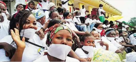  ?? AFP ?? Women with their mouths covered with pieces of cloth gather on the steps of the National Assembly in Bangui, the capital
■ of the Central African Republic, yesterday, during a demonstrat­ion to protest violence against women. Around a thousand people...