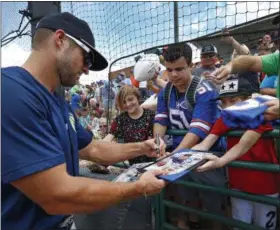  ?? THE HICKORY DAILY RECORD VIA AP ?? In this photo, Columbia Fireflies’ Tim Tebow accommodat­es some lucky fans with an autograph before a minor league baseball game against the Hickory Crawdads at L.P. Frans Stadium in Hickory, N.C. on April 30. The Single A teams of the South Atlantic League are seeing a burst in attendance whenever Tebow and the Columbia Fireflies go on the road.