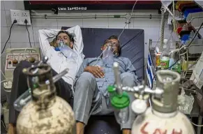  ?? — Reuters ?? Lack of space: Covid-19 patients sharing a bed at the casualty ward in Lok Nayak Jai Prakash Narayan Hospital in New Delhi.