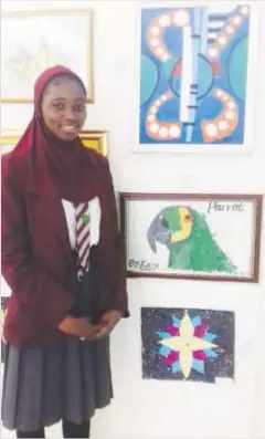  ??  ?? One of the student artist Zara Wakil next to her works