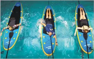  ?? Photograph­s by Kent Nishimura Los Angeles Times ?? EXERCISERS paddle on tethered boards in a class at Westside Jewish Community Center.